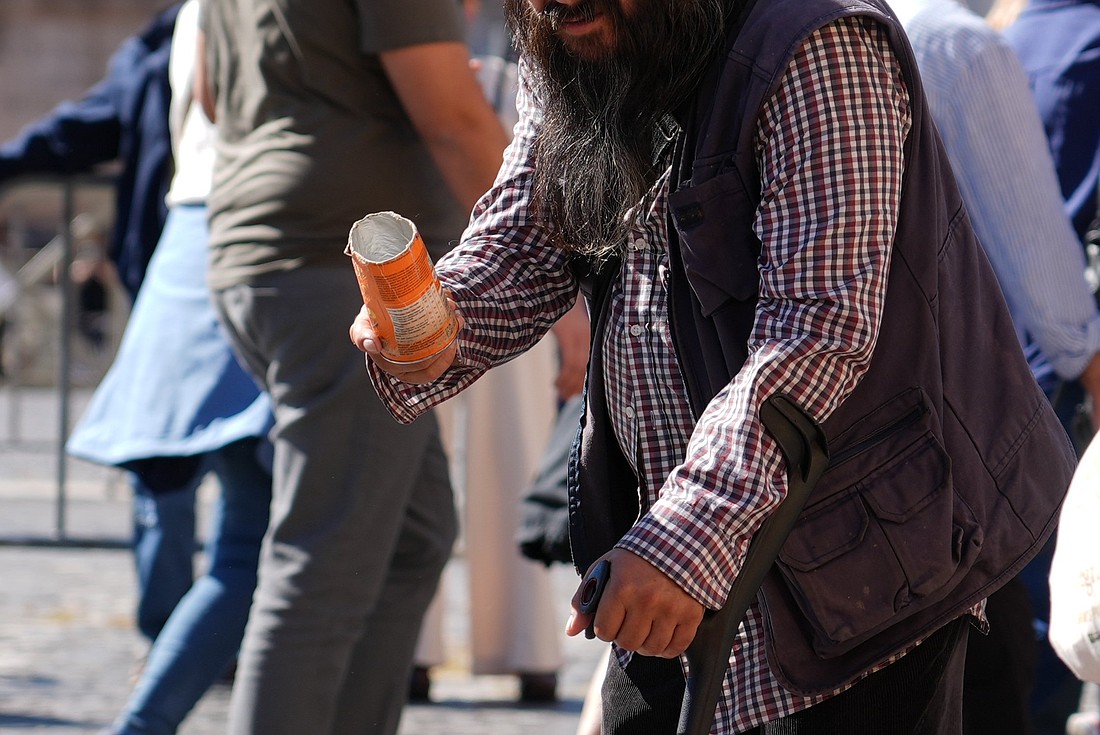 A person asks for alms near St. Peter’s Square at the Vatican Oct. 8, 2025. (CNS photo/Lola Gomez)