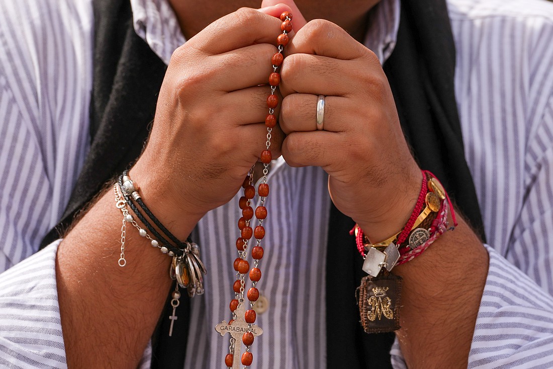 A person prays the rosary in St. Peter’s Square at the Vatican in this file photo from May 8, 2025. (CNS photo/Lola Gomez)