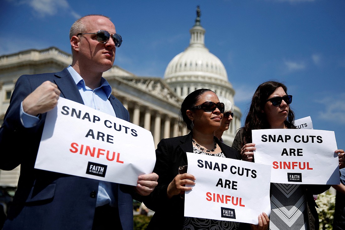 People hold up signs protesting against cuts to the Supplemental Nutrition Assistance Program during a press conference on Capitol Hill in Washington in this file photo. With funding for SNAP scheduled to lapse Nov. 1, 2025, due to the federal government shutdown, Catholic outreach leaders are warning that the increased need could stretch many hunger relief ministries, and those they serve, to the limit. (OSV News photo/Joshua Roberts, Reuters)