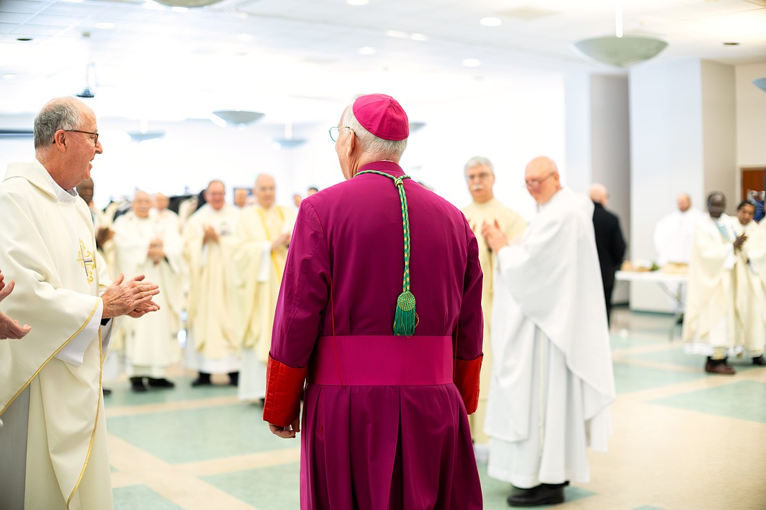 Bishop Mark W. O'Connell shares a laugh with priests and deacons before his Installation Mass at St. Edward the Confessor in Clifton Park on Friday, December 5, 2025. (Patrick Dodson photo)