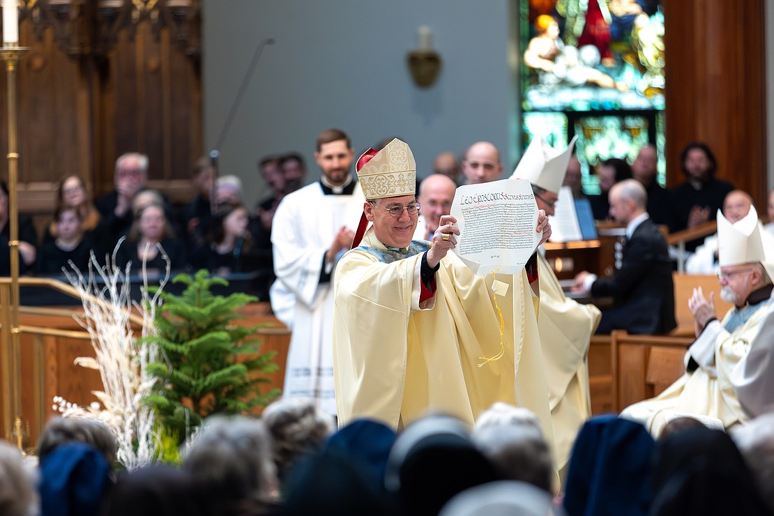 Bishop Mark O'Connell shows the Apostolic Mandate to the faithful after he is installed as the 11th Bishop of Albany (Patrick Dodson photo)