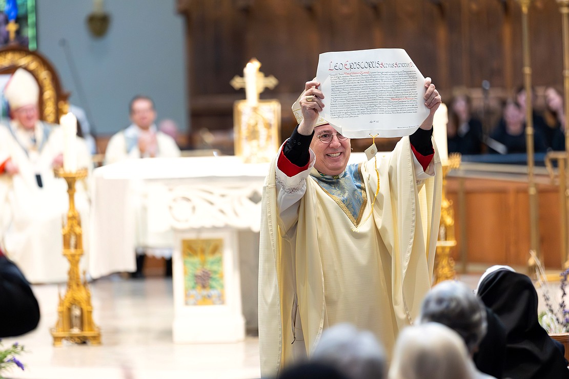 Bishop Mark O'Connell shows the Apostolic Mandate to the faithful after he is installed as the 11th Bishop of Albany (Patrick Dodson photo)