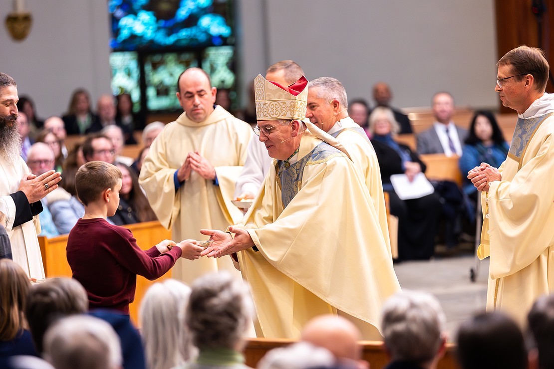 Bishop Mark O'Connell receives the Gifts from the McMaster family. (Patrick Dodson photo for The Evangelist)