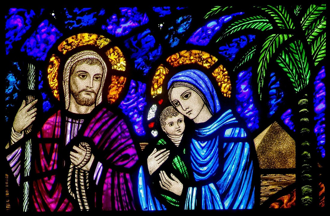 A detail of a stained-glass window from St. Edward's Church in Seattle shows Jesus, Mary and Joseph on their flight into Egypt. (OSV News illustration/Crosiers)