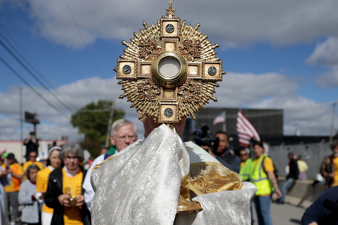 A priest carries a monstrance as members of a Catholic group take part in a procession near the U.S. Immigration and Customs Enforcement (ICE) Broadview facility in Chicago Oct. 11, 2025. The group had hoped to share holy Communion with detainees at the facility. (OSV News photo/Jeenah Moon, Reuters)