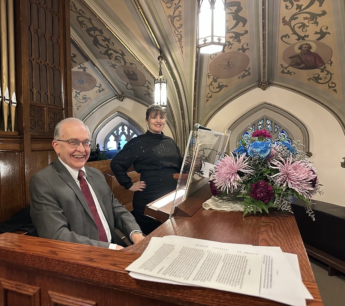 Alfred Fedak, professional organist and composer, and Alice Sorensen, music director for St. Stanislaus Church in Amsterdam, share a smile behind the parish’s newly restored organ at the instrument’s dedication concert in November 2025. (Provided photo)