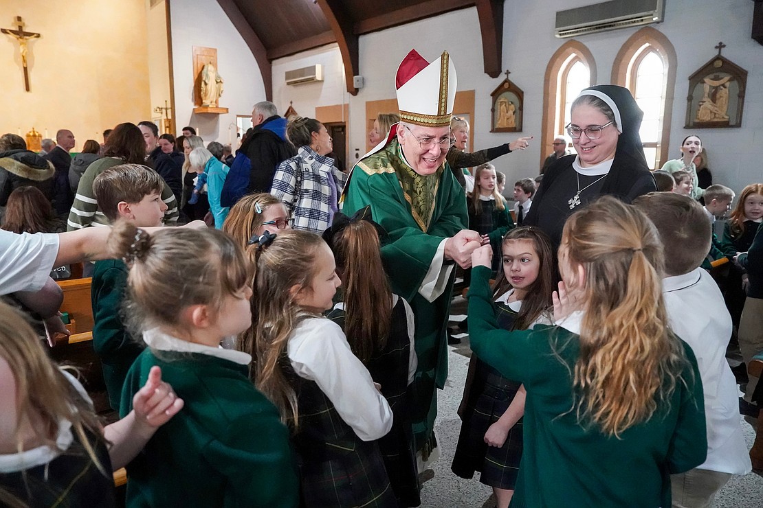 Bishop Mark O’Connell, center, fist bumps students after the Catholic Schools mass on Friday, Jan. 23, 2026, at St. Jude the Apostle Church in Wynantskill, N.Y.  Cindy Schultz for The Evangelist