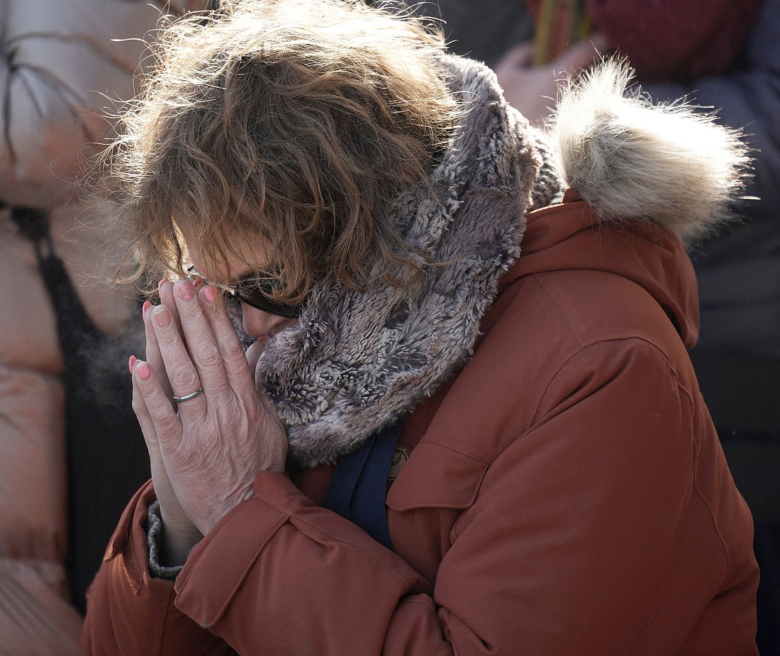 A woman prays at a makeshift memorial in Minneapolis Jan. 25, 2026, at the site where Alex Pretti, a 37-year-old intensive care unit nurse was fatally shot by federal agents trying to detain him. In a Jan. 28 statement, Archbishop Paul S. Coakley of Oklahoma City, president of the U.S. Conference of Catholic Bishops, calls for a Holy Hour for peace as a step toward national healing following a trio of recent killings by immigration enforcement personnel. (OSV News photo/Tim Evans, Reuters).