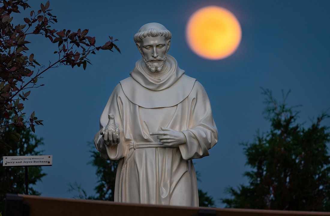 A hunter's moon rises behind a statue of St. Francis of Assisi on the grounds of the National Shrine of Our Lady of Champion in Champion, Wis., Oct 8, 2022 (OSV News photo/Sam Lucero, CNS)