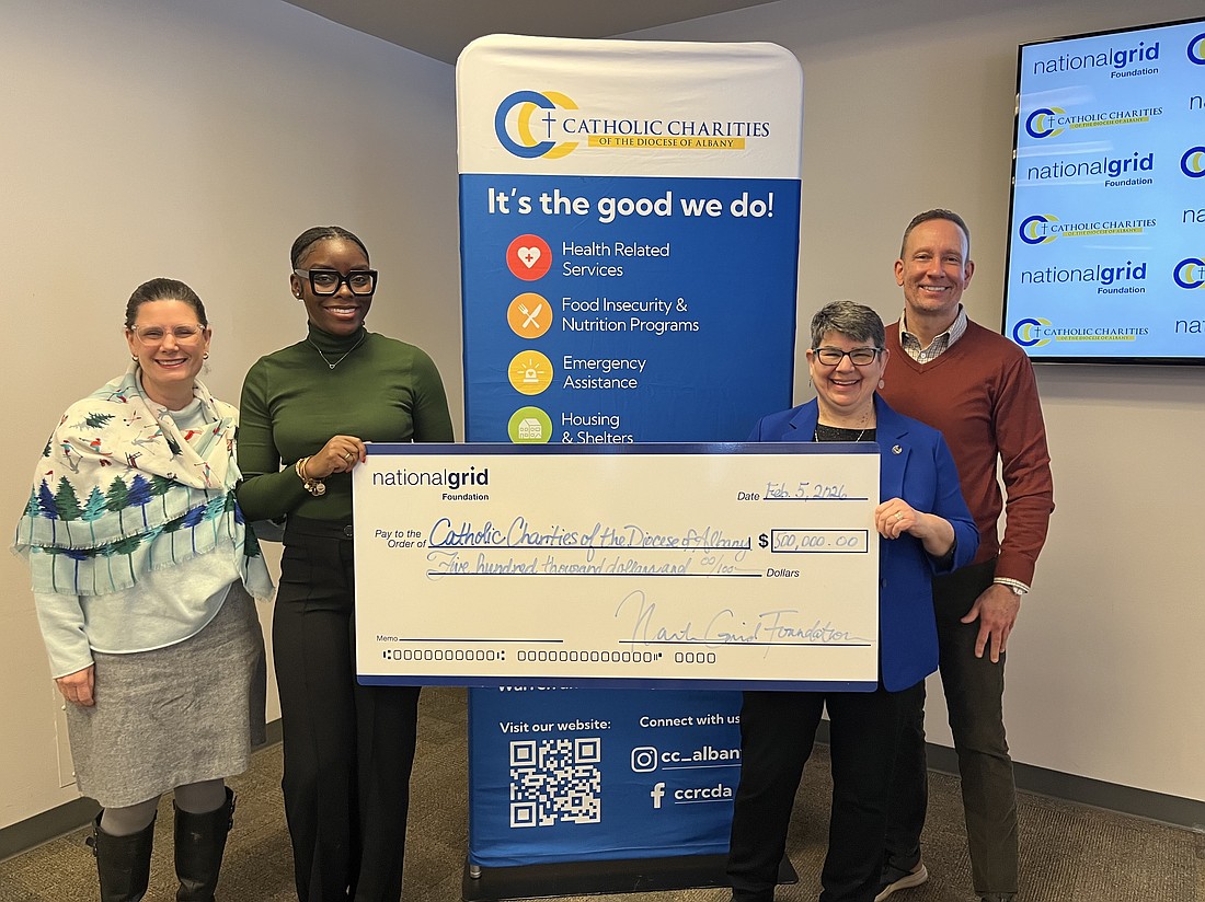 Kimberly Ireland (from l.), director of external affairs for National Grid, Kahri Fuller, program officer for the National Grid Foundation, Sister Betsy Van Deusen, CSJ, CEO of Catholic Charities of Albany, and Jim Salengo, external affairs manager for National Grid, present a check for $500,000 to Catholic Charities Emergency Energy Assistance Program. (Emily Benson photo)