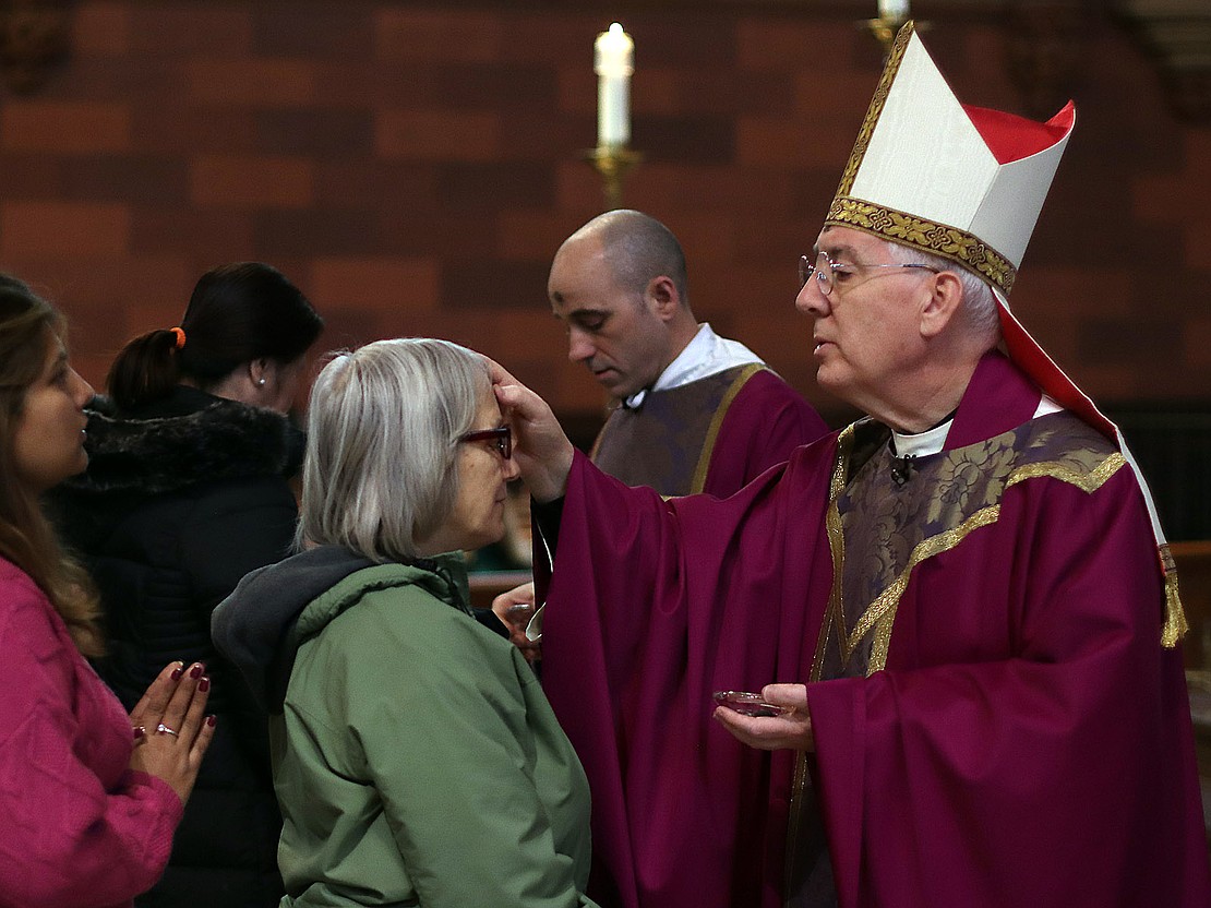 Bishop Mark O'Connell puts ashes on the forehead of Maribeth Krupczak of Albany during Ash Wednesday service at the Cathedral of the Immaculate Conception on Feb. 18. (Thomas Killips photo)