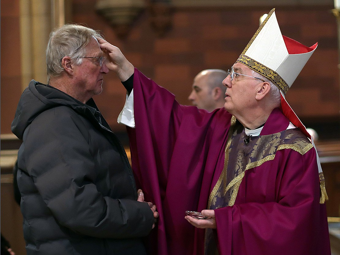 Bishop Mark O'Connell puts ashes on the forehead of Rick Harbeck of Rensselaer during Ash Wednesday service at the Cathedral of the Immaculate Conception on Feb. 18. (Thomas Killips photo)