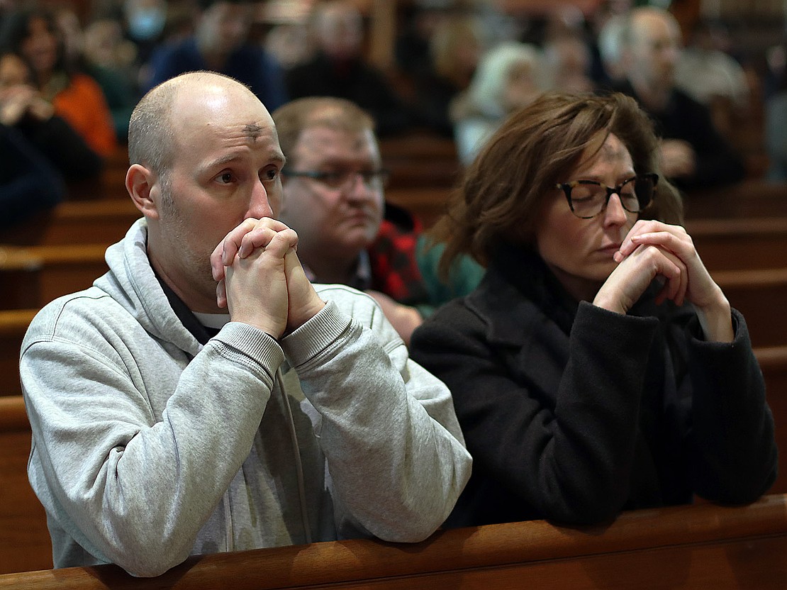 Gregory and Sarah Dykas of Albany pray after receiving ashes during the Ash Wednesday service at the Cathedral of the Immaculate Conception on Feb. 18. (Thomas Killips photo)