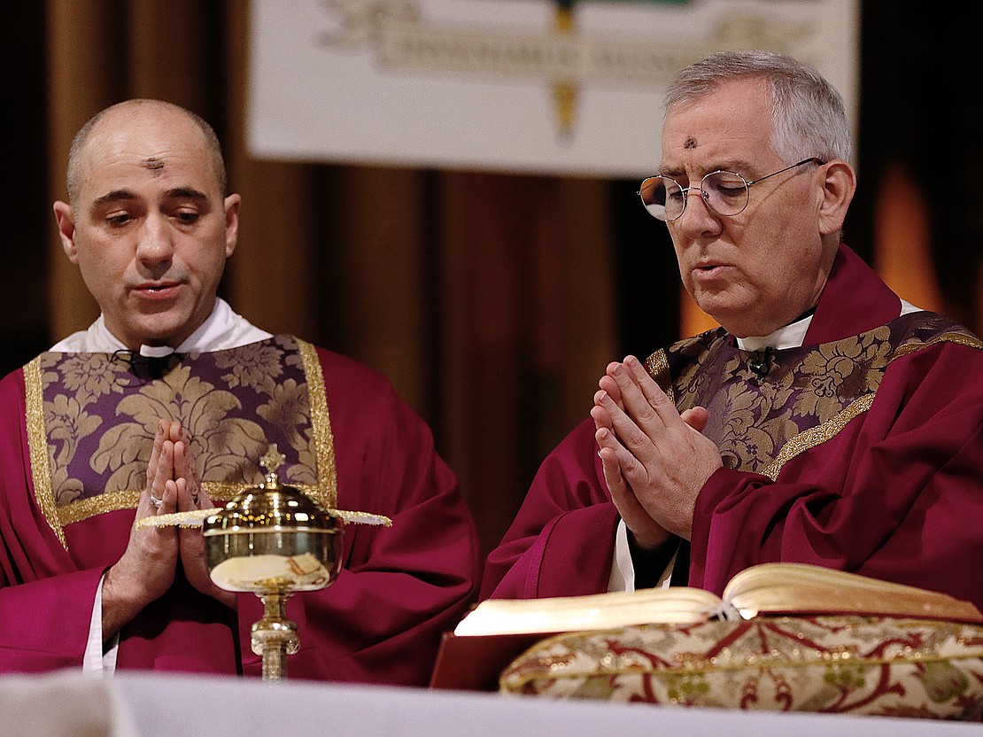 Deacon James Agnew and Bishop Mark O'Connell pray during communion at the Ash Wednesday service at the Cathedral of the Immaculate Conception on Feb. 18. (Thomas Killips photo)