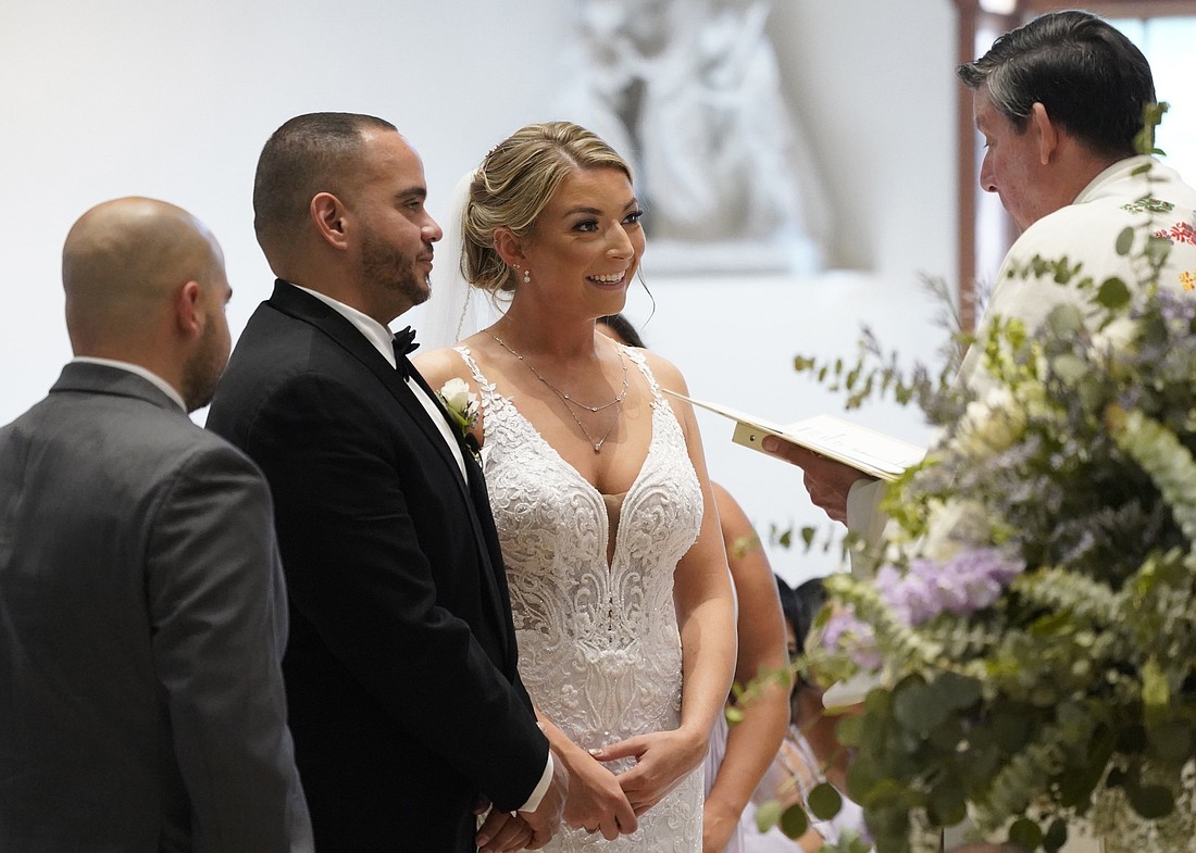 Julio Prendergast and Christina MacDougall look at Msgr. Francis J. Schneider as he officiates their wedding Mass Aug. 20, 2021, at St. John the Baptist Church in Wading River, N.Y. (OSV News photo/Gregory A. Shemitz)