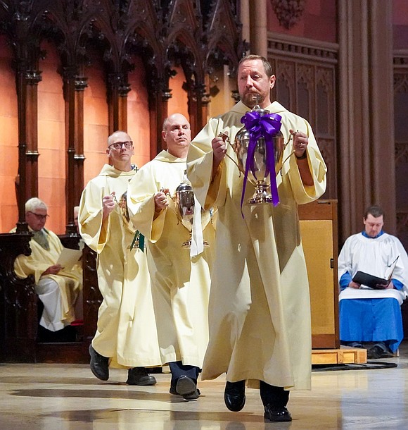 Deacons carry the urns to the front of the altar during the Chrism Mass on March 30 at the Cathedral of Immaculate Conception in Albany. (Cindy Schultz photo for The Evangelist)