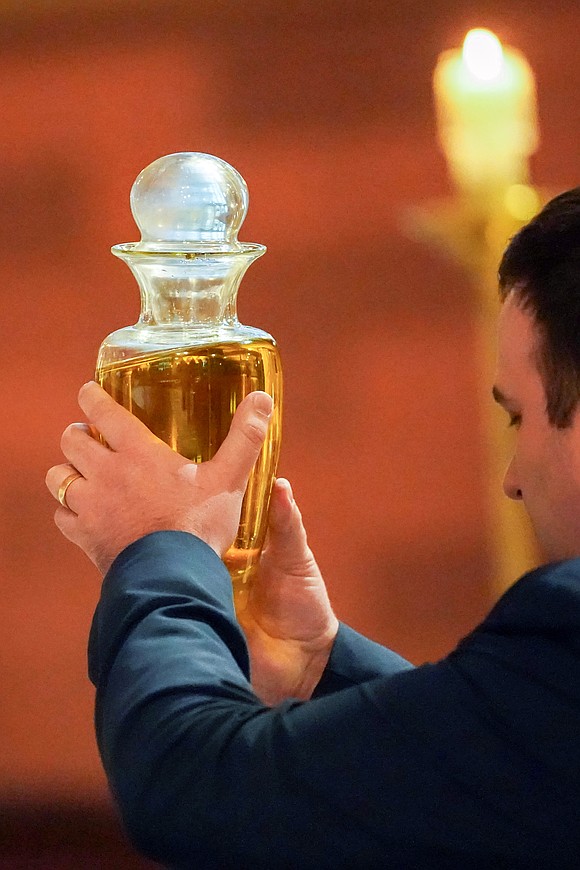 Oil bearer Kyle Bryan carries the Oil of the Catechumens to the altar during the Chrism Mass on March 30 at the Cathedral of Immaculate Conception in Albany. (Cindy Schultz photo for The Evangelist)