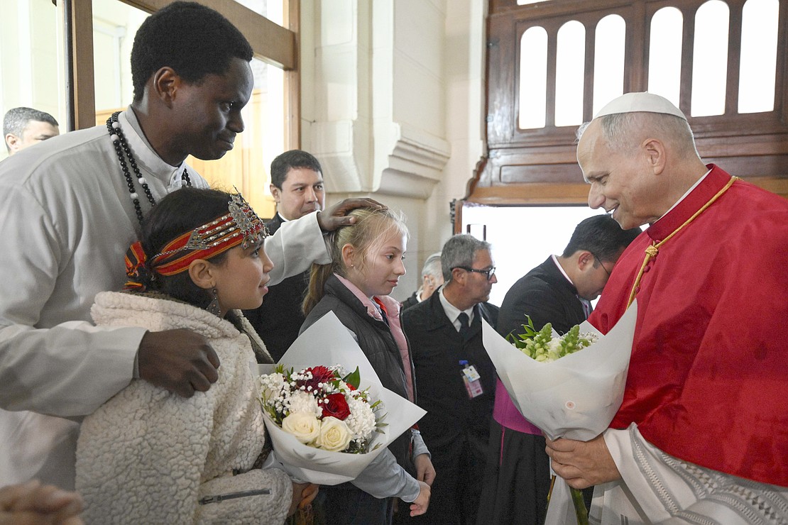 Pope Leo XIV greets a man and young women as he attends a meeting with the Algerian community at the Basilica of Our Lady of Africa in Algiers, Algeria, April 13, 2026. (OSV News photo/Simone Risolutie, Vatican Media)