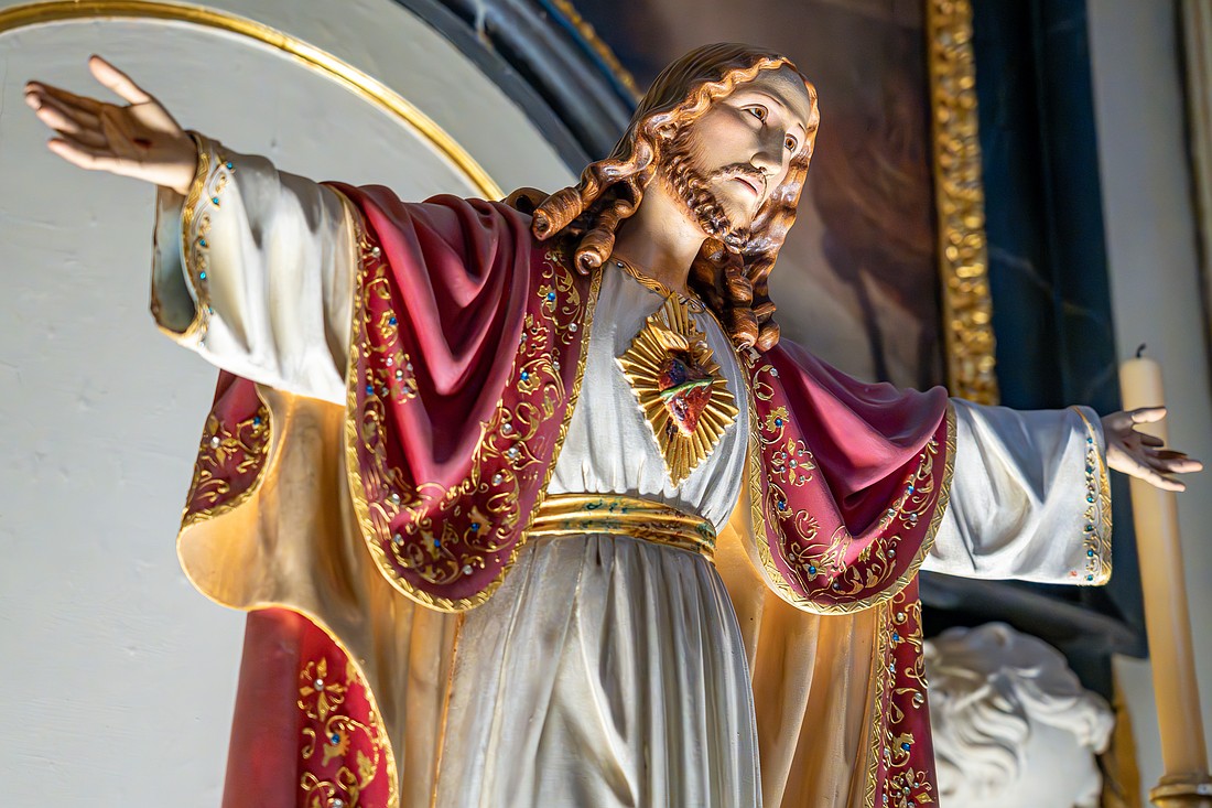 Statue of the Sacred Heart of Jesus prominently displayed on the altar of the Christian church of São Sebastião da Pedreira in Lisbon.