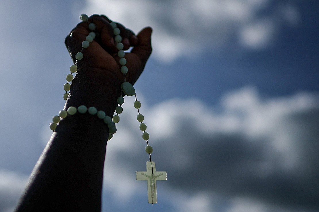 A faithful holds a rosary ahead of a prayer service led by Pope Leo XIV at the "Mama Muxima" Shrine, during his apostolic journey in Africa, in Muxima, Angola, April 19, 2026. (OSV News photo/Guglielmo Mangiapane, Reuters)