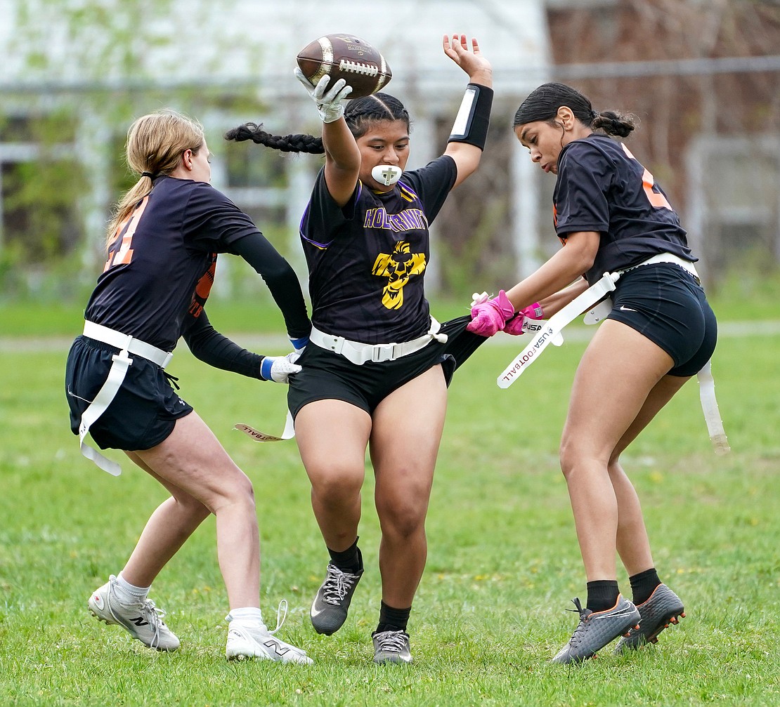 Holy Trinity’s Carmel Bernardino attempts to elude Mohonasen defenders as they try to pull her flags during the Pride's flag football game against Mohonasen on April 29 at Notre Dame-Bishop Gibbons School in Schenectady. Holy Trinity won 34-6. (Cindy Schultz photo for The Evangelist)
