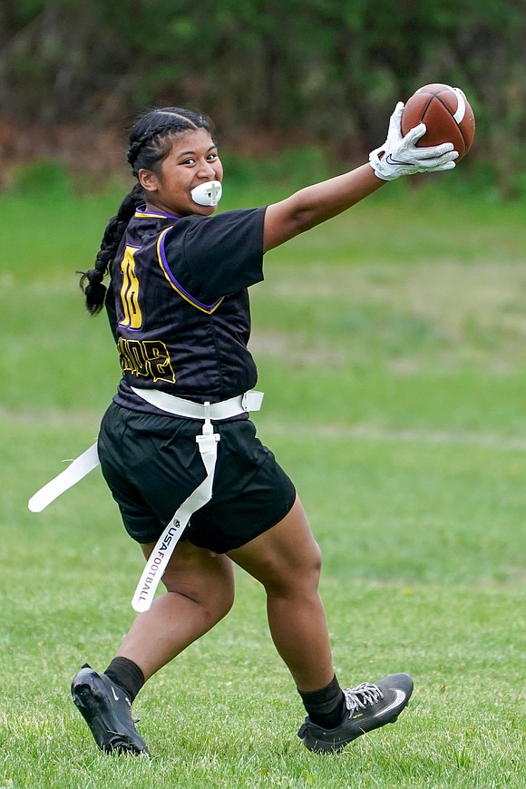 Holy Trinity’s Carmel Bernardino smiles back at the bench and her coaches as she scores a touchdown during the Pride's flag football game against Mohonasen on April 29 at Notre Dame-Bishop Gibbons School in Schenectady. Holy Trinity won 34-6. (Cindy Schultz photo for The Evangelist)