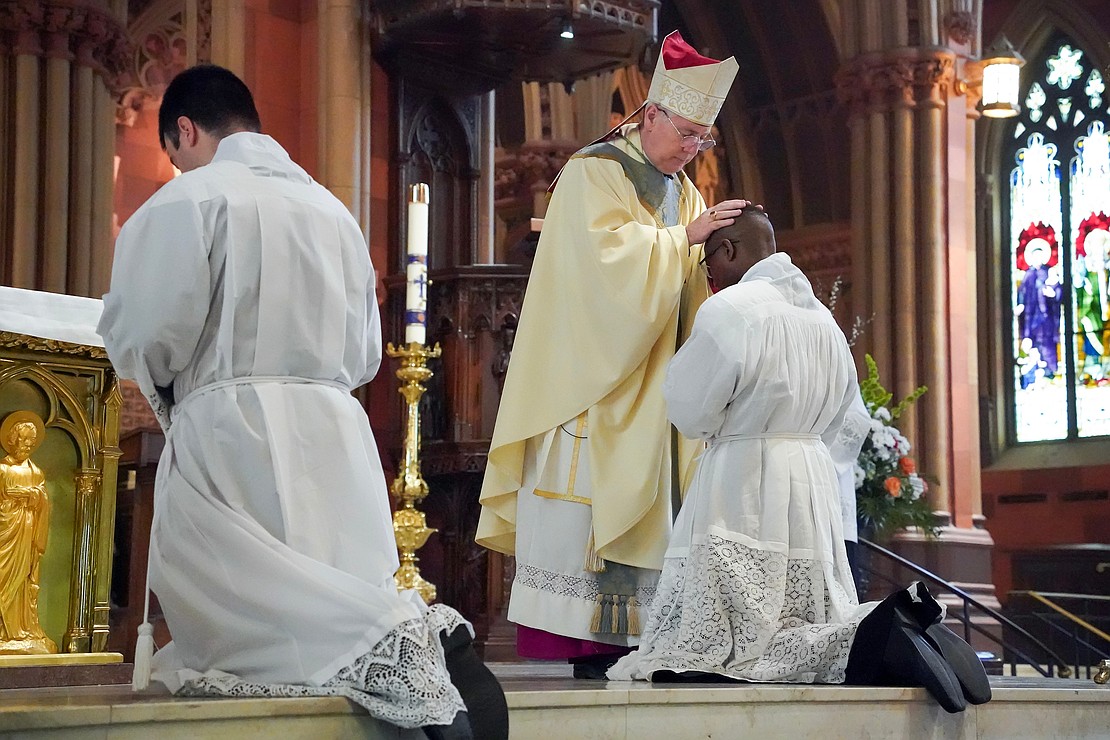 Bishop Mark O’Connell lays hands on candidate for deacon Gilbert Kimaro during the Mass of Ordination to the Priesthood and Diaconate on May 16 at the Cathedral of the Immaculate Conception in Albany. (Cindy Schultz photo for The Evangelist)