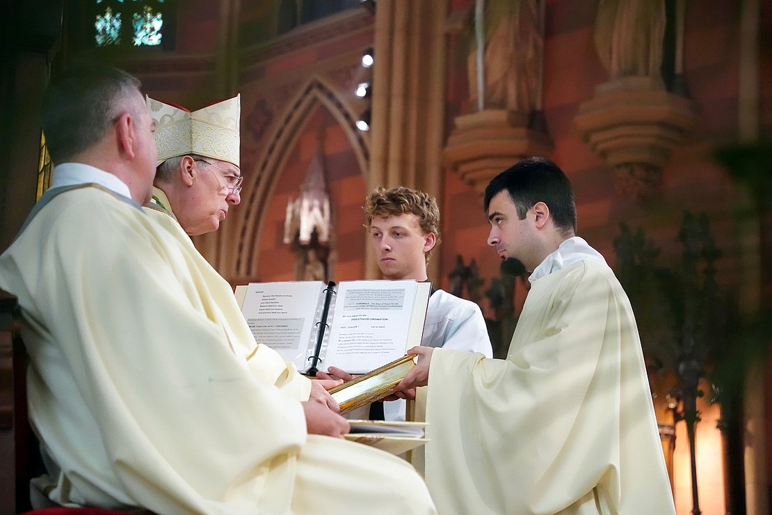 Bishop Mark O’Connell hands the Book of the Gospels to newly ordained Deacon Alessio Fasullo during the Mass of Ordination to the Priesthood and Diaconate on May 16 at the Cathedral of the Immaculate Conception in Albany. (Cindy Schultz photo for The Evangelist)