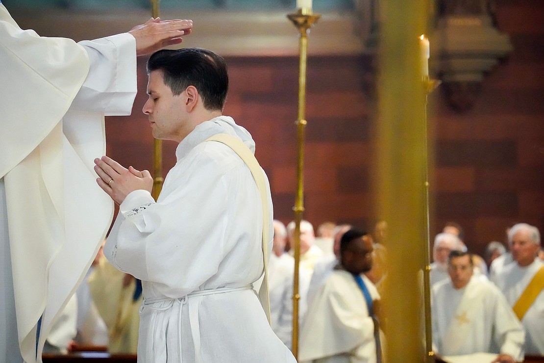 Priests lay their hands upon the candidate for the priesthood, Alexander Turpin, during the Mass of Ordination to the Priesthood and Diaconate on May 16 at the Cathedral of the Immaculate Conception in Albany. (Cindy Schultz photo for The Evangelist)