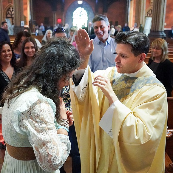Newly ordained Father Alexander Turpin blesses Lauren Numrich, campus minister at La Salle Institute, following the Mass of Ordination to the Priesthood and the Diaconate on May 16 at the Cathedral of the Immaculate Conception in Albany. (Cindy Schultz photo for The Evangelist)t