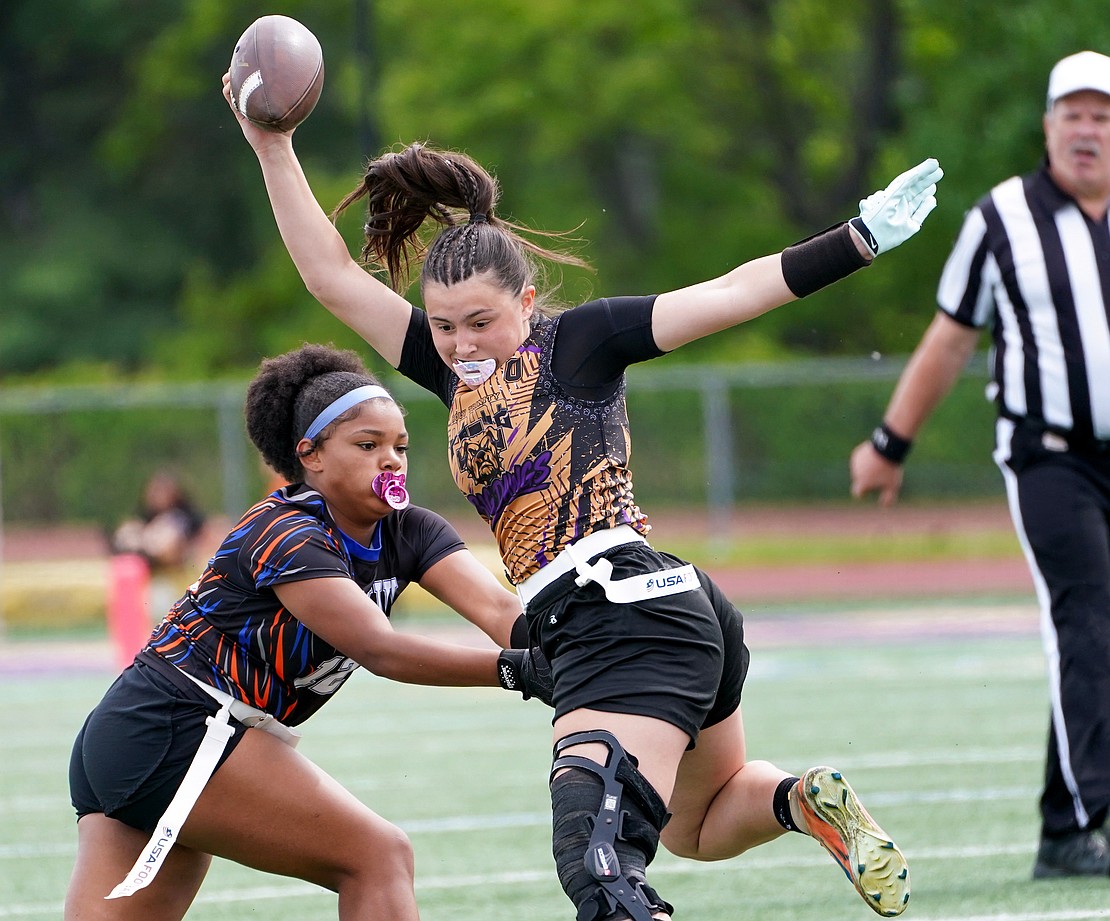 Holy Trinity quarterback Ella DiBacco tries to stay out of reach as Catskill’s Sapphire Manigault grabs at a flag during the Pride's Section 2 Class C flag football final on May 22 at Christian Brothers Academy. (Cindy Schultz photo for The Evangelist)