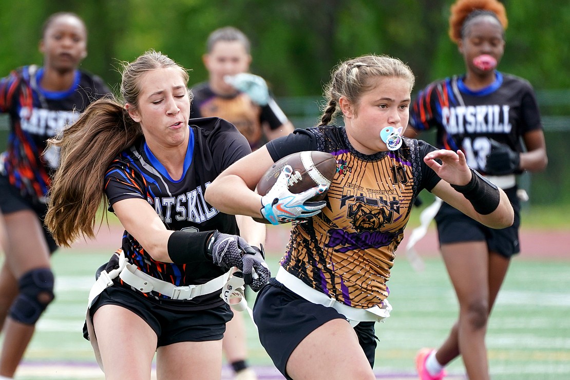 Holy Trinity’s Sophia Gundlach gains yards as Catskill’s Emmorsen Abrahamsen grabs a flag during the Pride's Section 2 Class C flag football final on May 22 at Christian Brothers Academy. (Cindy Schultz photo for The Evangelist)