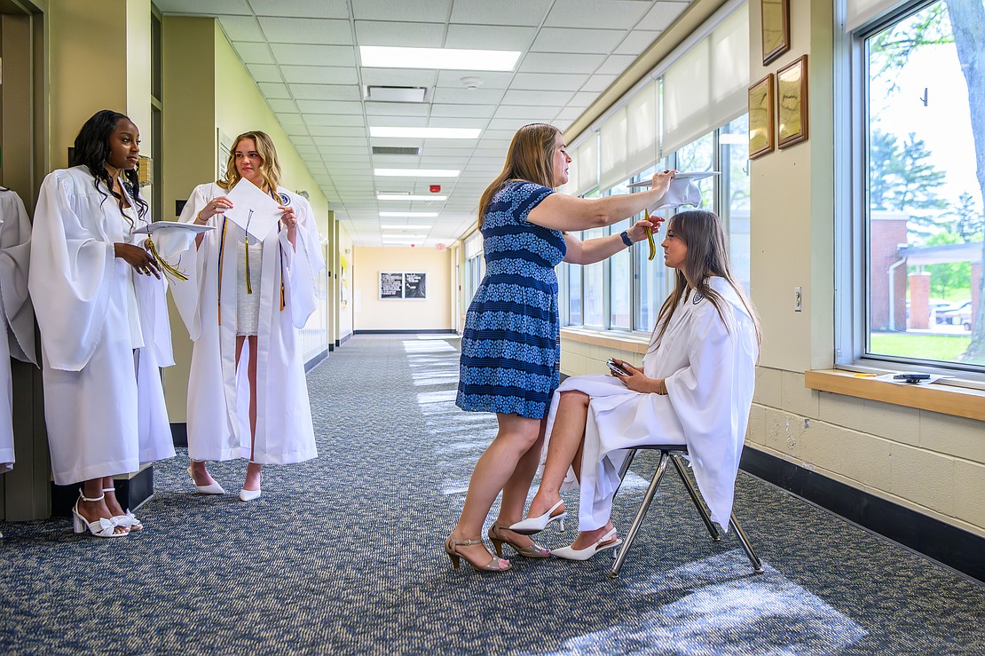 Danielle LeBuis Koenig, senior class advisor, helps senior class President Ella Schoenborn with her cap before the commencement exercises on May 22 at the Academy of the Holy Names in Albany. (Vincent Giordano photo for The Evangelist)