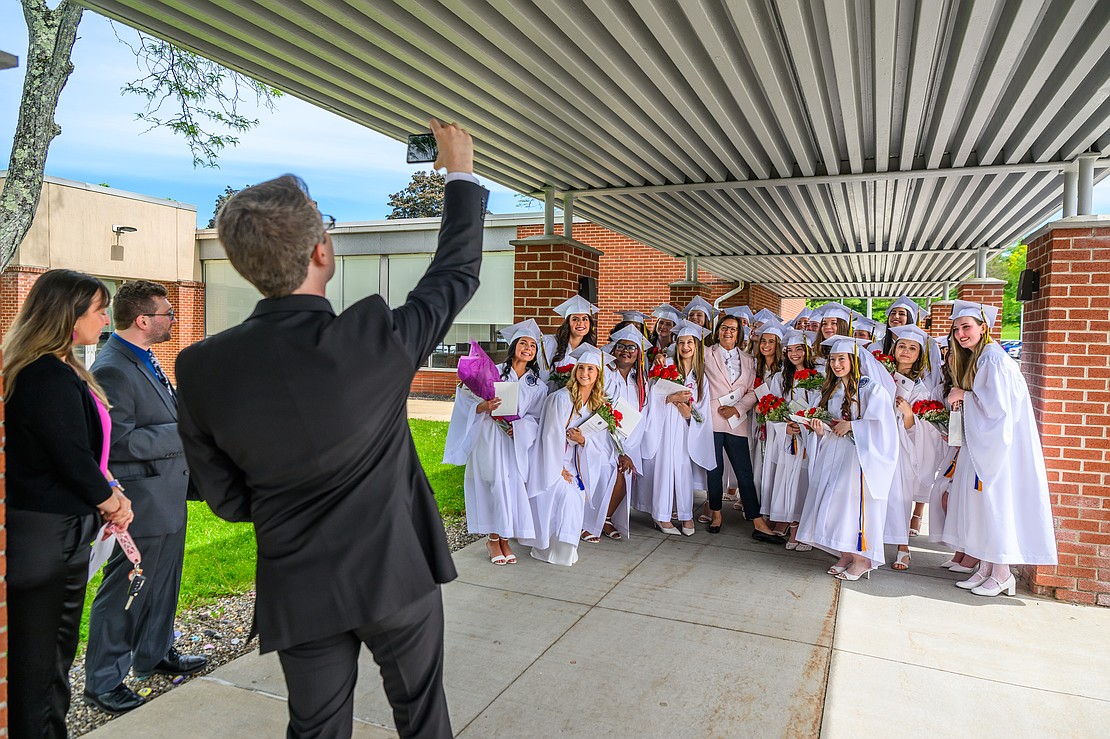Biology teacher Matthew Baxter takes a photo of graduates with advisor and service project coordinator Bernadette McSparron after commencement exercises on May 22 at the Academy of the Holy Names in Albany. (Vincent Giordano photo for The Evangelist)