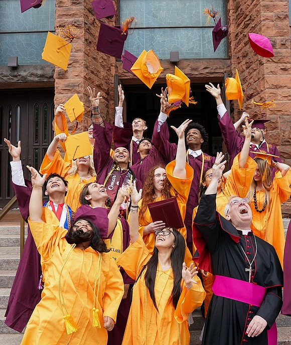 Bishop Mark McConnell tosses his zuchetto as he joins graduates when they toss their mortarboards during the Notre Dame-Bishop Gibbons commencement exercises on June 6 at St. John the Evangelist in Schenectady. (Cindy Schultz photo for The Evangelist)