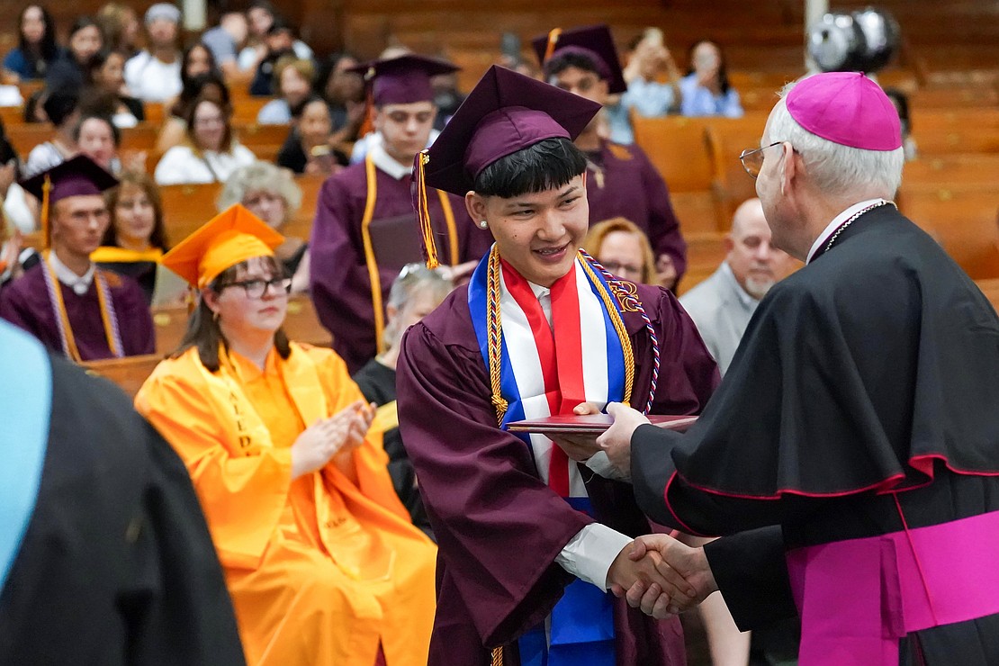 Graduate Say Ber Htoo receives his diploma from Bishop Mark O’Connell during the Notre Dame-Bishop Gibbons commencement exercises on June 6 at St. John the Evangelist in Schenectady. (Cindy Schultz photo for The Evangelist)