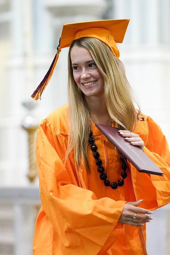 Graduate Marli Pippert is all smiles when she collects her diploma during the Notre Dame-Bishop Gibbons commencement exercises on June 6 at St. John the Evangelist in Schenectady. (Cindy Schultz photo for The Evangelist)