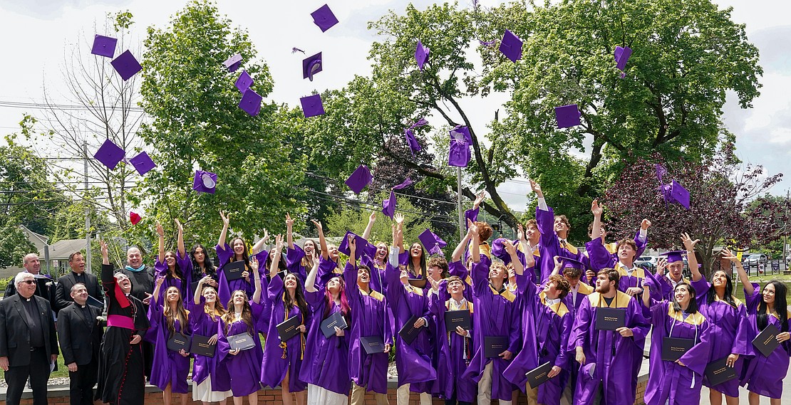 Bishop Mark McConnell (front row, third from l.) tosses his zuchetto as he joins graduates when they toss their mortarboards following Saratoga Catholic Central's commencement exercises on June 26 at St. Clement’s Church in Saratoga Springs. (Cindy Schultz photo for The Evangelist)