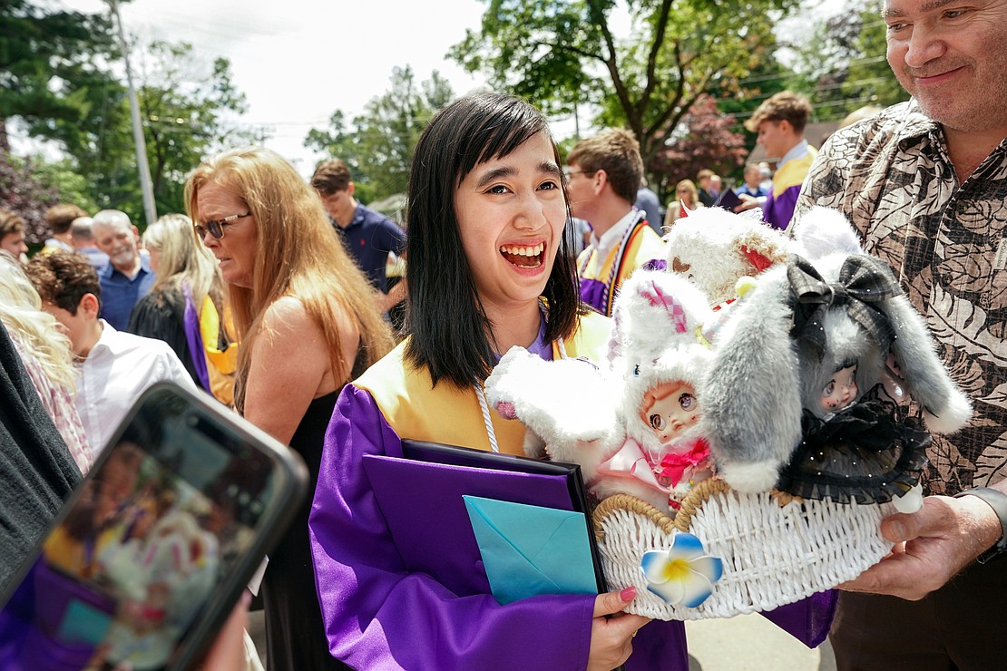 Graduate Ghinghar Moe Thu receives a basket of dolls in lieu of flowers following Saratoga Catholic Central's commencement exercises on June 26 at St. Clement’s Church in Saratoga Springs. (Cindy Schultz photo for The Evangelist)