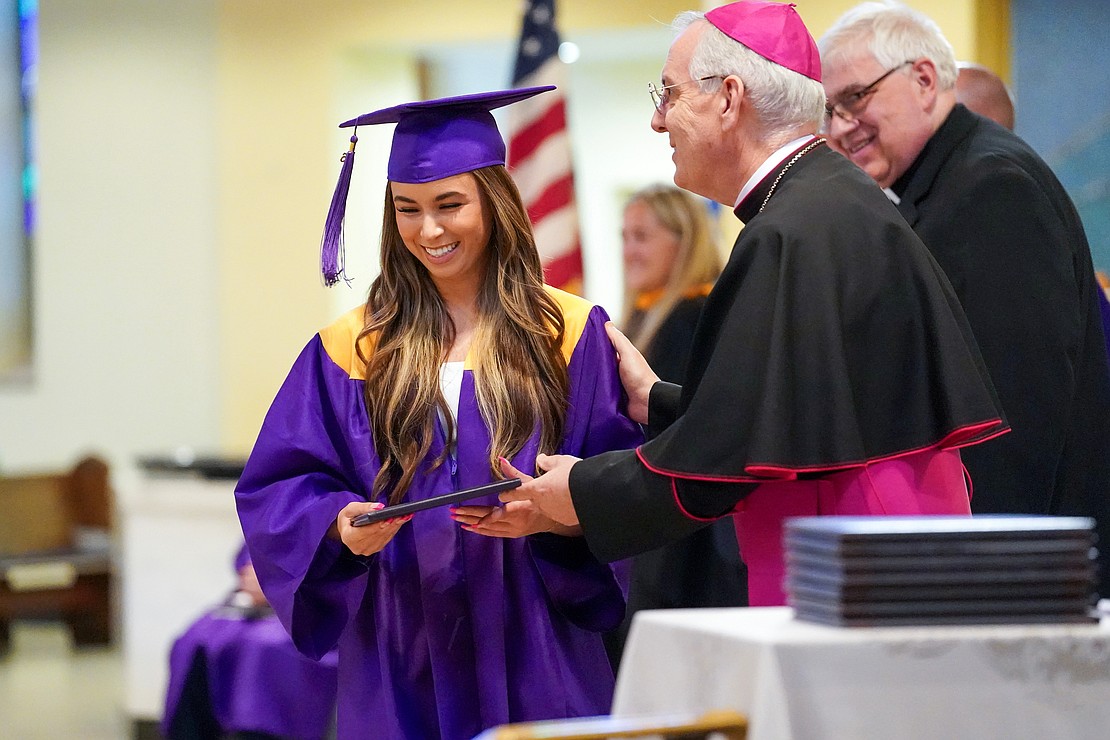 Graduate Angelica Dugan receives her diploma from Bishop Mark O’Connell during Saratoga Catholic Central's commencement exercises on June 26 at St. Clement’s Church in Saratoga Springs. (Cindy Schultz photo for The Evangelist)