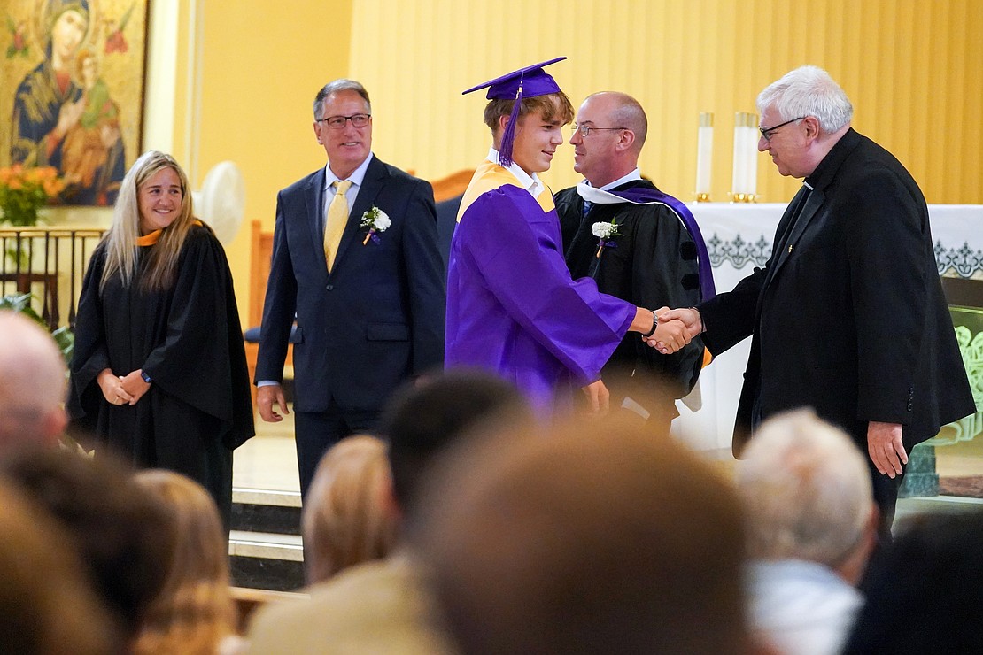 Graduate Kihl Kelly shakes hands with Father Bob Longobucco during Saratoga Catholic Central's commencement exercises on June 26 at St. Clement’s Church in Saratoga Springs. (Cindy Schultz photo for The Evangelist)