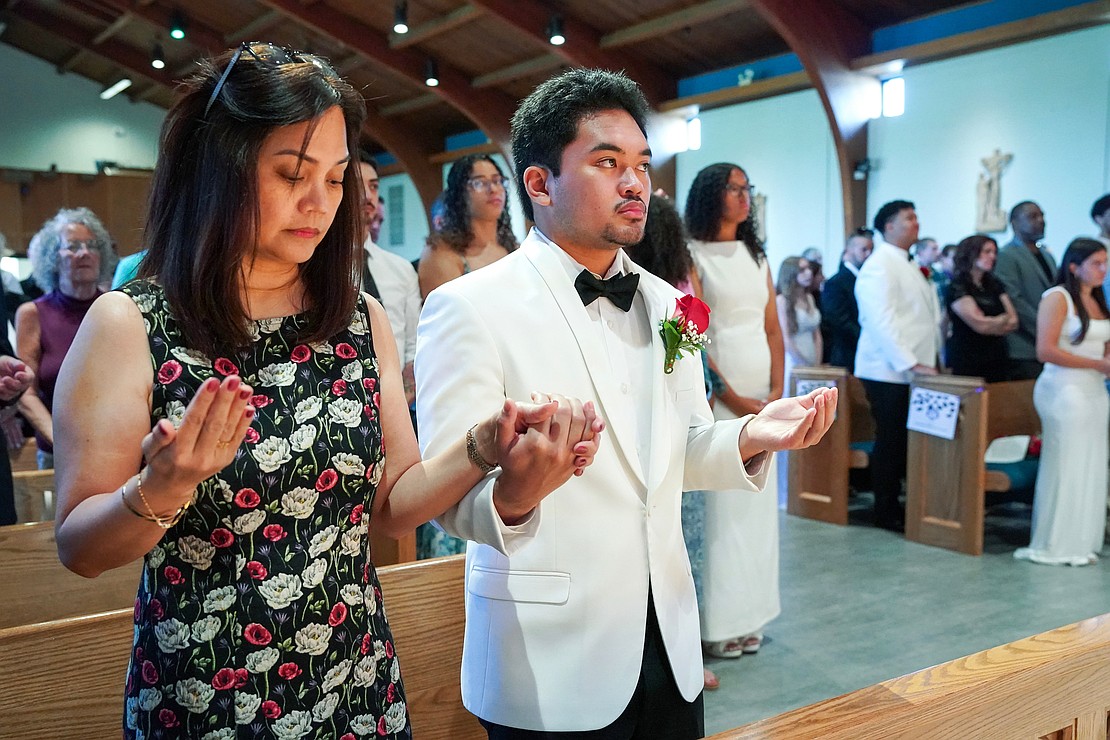 Valedictorian Jeremy Climaco prays with his mother, Jasmine, during Mass before Catholic Central School's commencement exercises on June 27 at St. Ambrose Church in Latham. (Cindy Schultz photo for The Evangelist)
