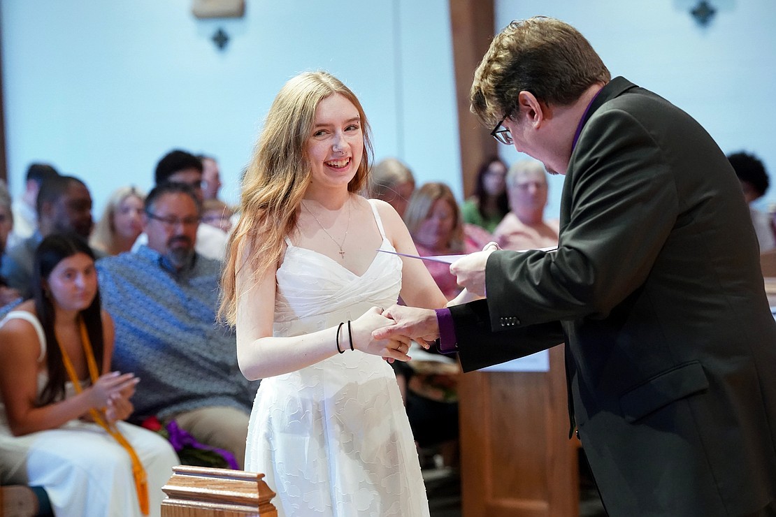 Graduate Emma Barno receives an award from principal Richard Harrigan during Catholic Central School's commencement exercises on June 27 at St. Ambrose Church in Latham. (Cindy Schultz photo for The Evangelist)