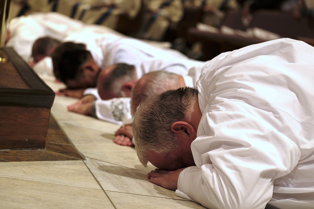 Men lie prostrate during their ordination to the diaconate at the Catholic Pastoral Center in Nashville, Tenn., April 1, 2023. Bishop J. Mark Spalding of Nashville ordained 12 permanent deacons and one transitional deacon. (OSV News photo/Katie Peterson, Tennessee Register)