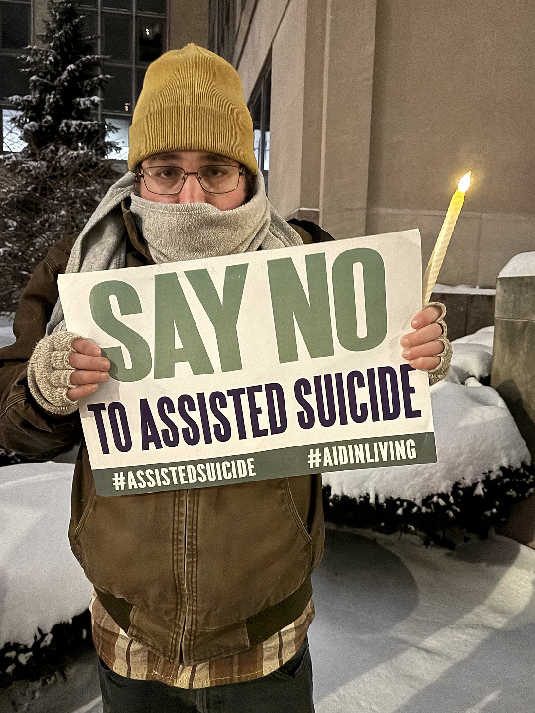 A demonstrator against assisted suicide displays a sign during a candlelight vigil outside the Sen. John H. Hughes Office Building in downtown Syracuse, N.Y., Dec. 4, 2025. On Aug. 5, 2026, New York's new medical assistance in dying law goes into effect. (OSV News photo/Tami S. Scott, The Catholic Sun)