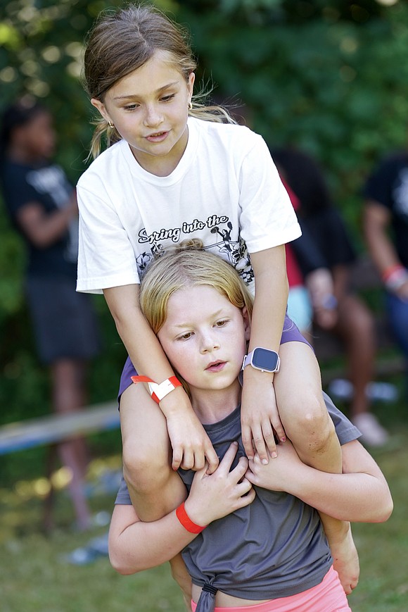 Kynlee McCollum, 8, carries Mila Nunziato, 8, on her shoulders on Aug. 4 at Camp Scully in Wynantskill. (Cindy Schultz photo for The Evangelist)