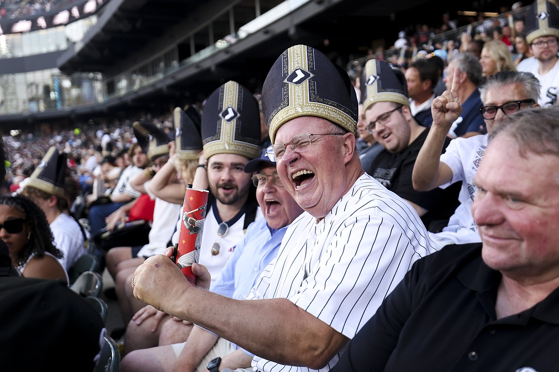 White Sox fans smile while wearing "pope hats" at an Aug. 11, 2026, baseball game at Rate Field in Chicago. The White Sox game paid tribute to Pope Leo XIV, a native of Dolton, Ill., with a first pitch thrown by a nun, a performance by the ChiTown Popes, and a fifth inning "sign of peace" while taking on the Cincinnati Reds. (OSV News photo/courtesy of the Chicago White Sox)