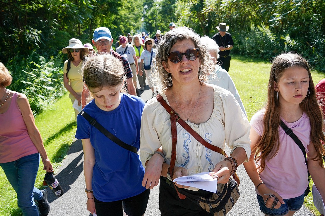 Meghan Breen of New Scotland, (c.) a parishioner at St. Vincent de Paul, walks and prays with her daughters Brigid, 13, (l.), and Nora, 11,  during the Pilgrimage for Peace on Saturday, Aug. 22. The event started at the National Shrine of the North American Martyrs in Auriesville. Participants, praying the rosary and singing songs, walked six miles to the Saint Kateri Tekakwitha National Shrine and Historic Site in Fonda. (Cindy Schultz photo for The Evangelist)