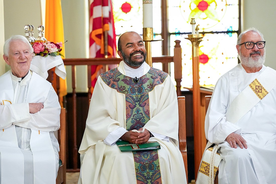 Father Justin Thomas (c., flanked by Father Terence P. Healy and Deacon Mike Carbone) is all smiles during his installation as pastor of the four parishes that make up the Family of the Holy Cross Network and incardination into the Diocese of Albany on Sept. 5, at St. Francis de Sales Church in Herkimer. (Cindy Schultz photo for The Evangelist)