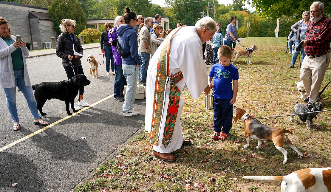 Deacon Richard Thiesen, center, with the help of Joshua Obermayer, 5, prepares to sprinkle holy water during the Pet Blessing and Adoption Clinic on Sunday, Oct. 4, at Christ Our Light Church in Loudonville. (Cindy Schultz photo for The Evangelist)